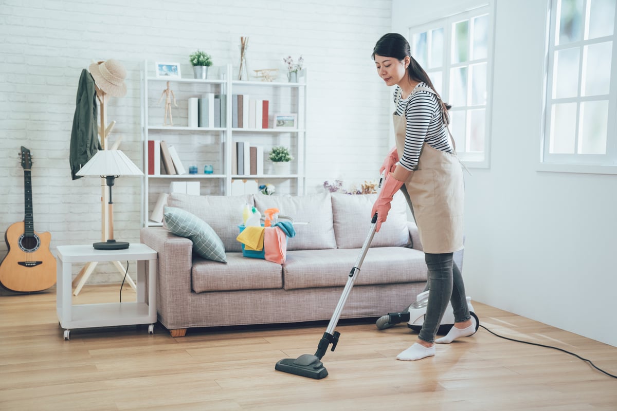 Young Housemaker Using Vacuum Cleaner Cleaning